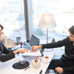 Mentor guides student reviewing application details for the **barry griswell scholarship** in an office setting.