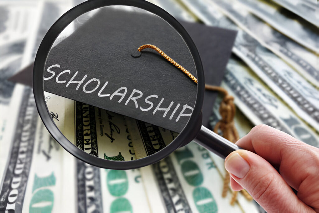 Graduation cap with the word "Scholarship" under magnifying glass over US dollar bills, symbolizing A 1 Auto Transport Scholarship opportunity