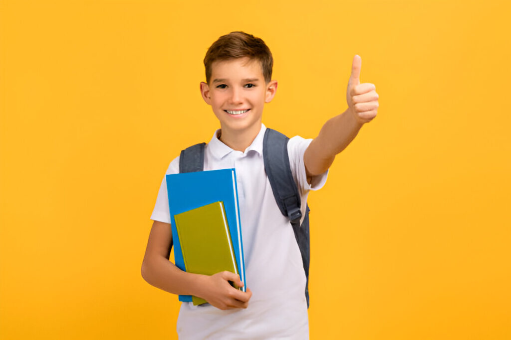 how to create a scholarship fund: a smiling student holding books and giving a thumbs up.