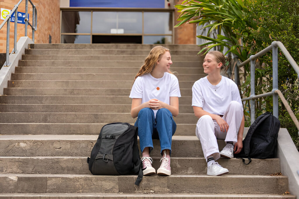 Two students on the steps of Swinburne University campus illustrating swinburne scholarships in action.