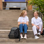 Two students on the steps of Swinburne University campus illustrating swinburne scholarships in action.